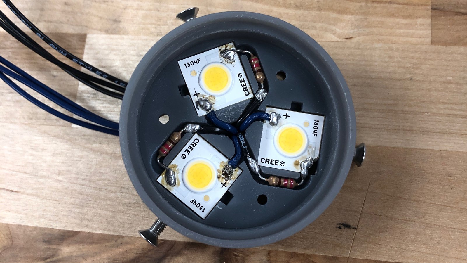  The Core consists of three high-intensity COB LEDs, producing a maximum 1,275 lumens. In theory, Lenses and Cores of varying characteristics can be easily switched out by the user to alter the light as they see fit. For instance: this Core's color temperature is a cool 5000K to offset the clear resin lens that develops a warmer temperature when post-cured with UV light, creating a soothing neutral white. (Pardon the battered LED wafers, these were frequently recycled for multiple prototypes.) 